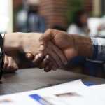 Closeup of people handshaking in office