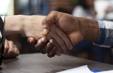 Closeup of people handshaking in office