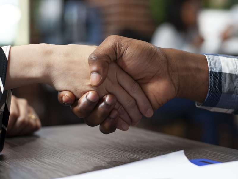 Closeup of people handshaking in office