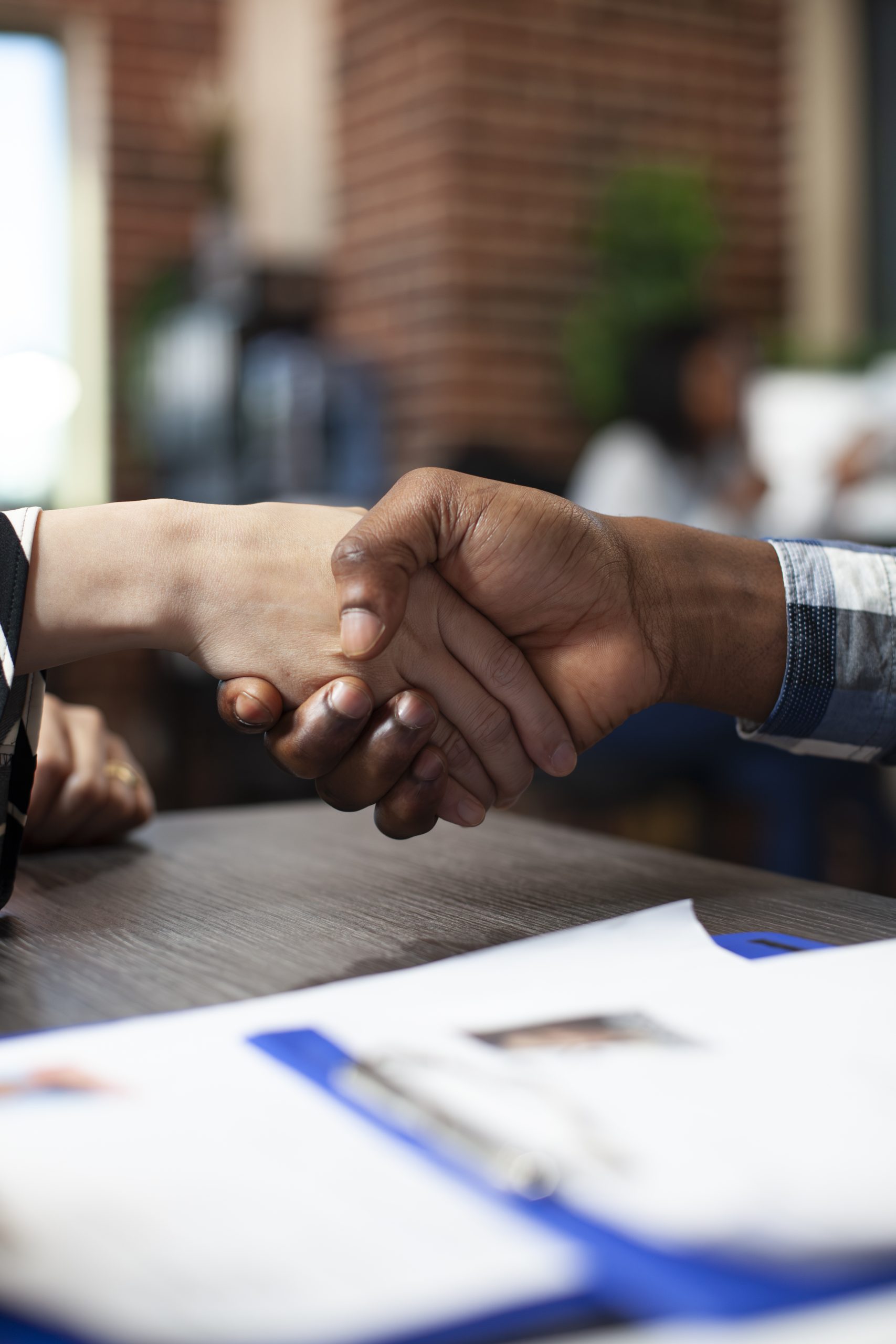 Closeup of people handshaking in office